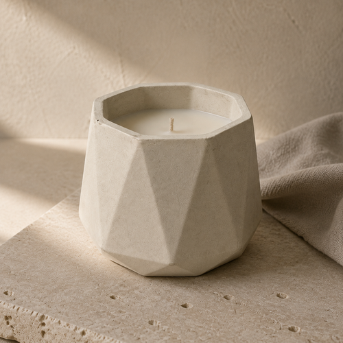 120 g tester candle with an unlit cotton wick in a faceted cream concrete vessel on limestone. AI-assisted visual.