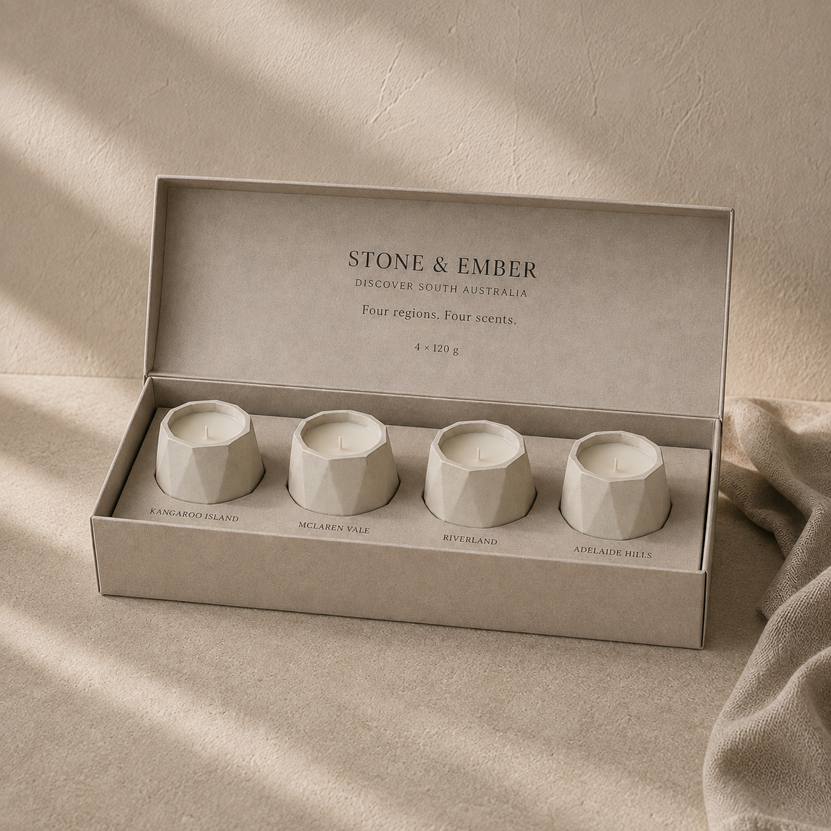 Discover South Australia pack with four cotton-wick candles in cream concrete vessels, presented in a single-row gift box. AI-assisted visual.